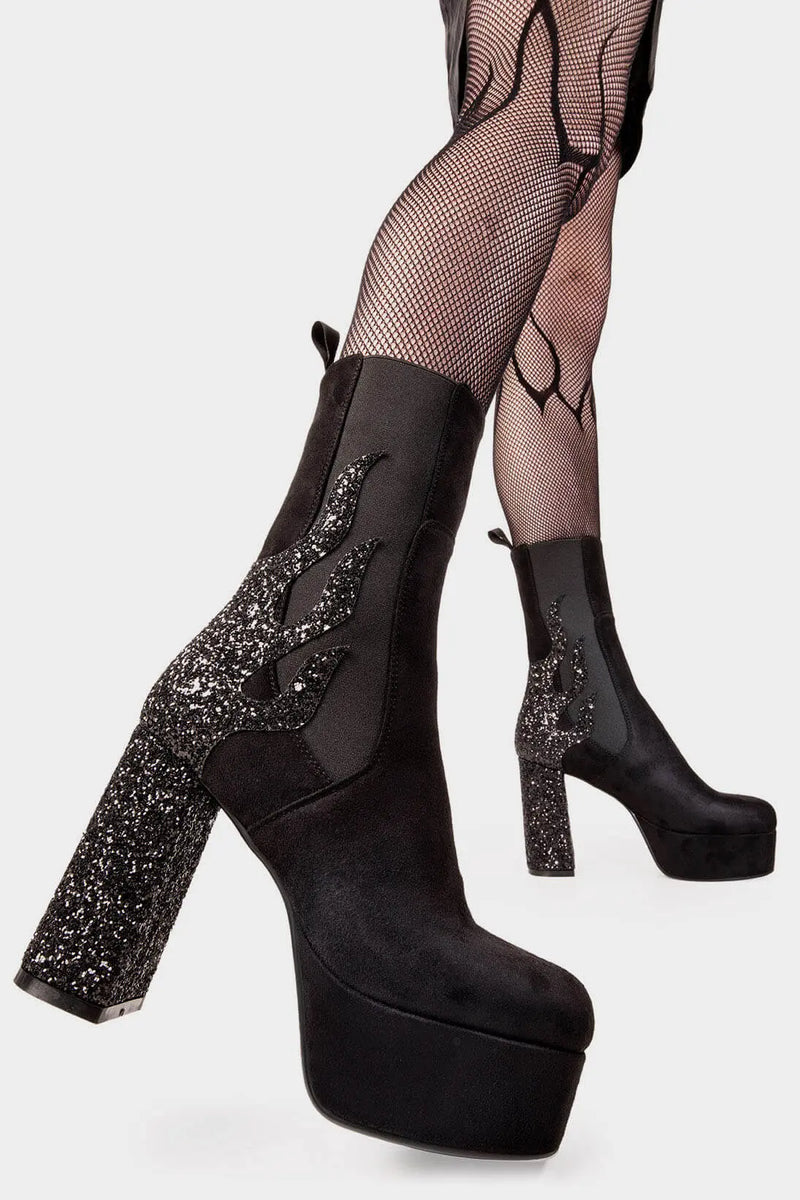 Burning Trails
  
 Apparent Lies Platform Calf Boots Boot in Black Suede. These black vegan Platform Boots feature black glitter flame detail to the back of the heel with a stretchy gusset detail, heat up your style game! Made with eco-friendly materials and 100% cruelty-free.
 
 - Platform Height: 2.6 inch
 - Heel Height: 5.5 inch
 - Gusset detail 
 - Wide calf and ankle friendly 
 - Platform Sole 
 - Round Toe
 - 100% vegan 
 
 SKU: LMF 2038 - BlackSUEDE/BlackGlitter