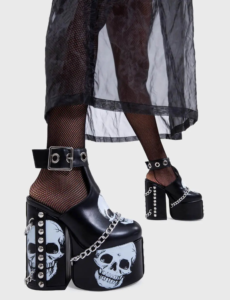 Skull Stomperss
  
  Hidden Closet Platform Heels in Black faux leather. These platform heels feature a skull design throughout and T bar structure ankle strap with square shaped buckle, make bold steps and leave a lasting impression.
  
  - Platform Height
  - Heel Height
  - Adjustable ankle strap
  - Silver eyelets and square shaped buckles
  - Skull design
  - Silver chain
  - Silver spiked studs
  - Chunky Platform sole
  - Round Toe 
  - 100% vegan