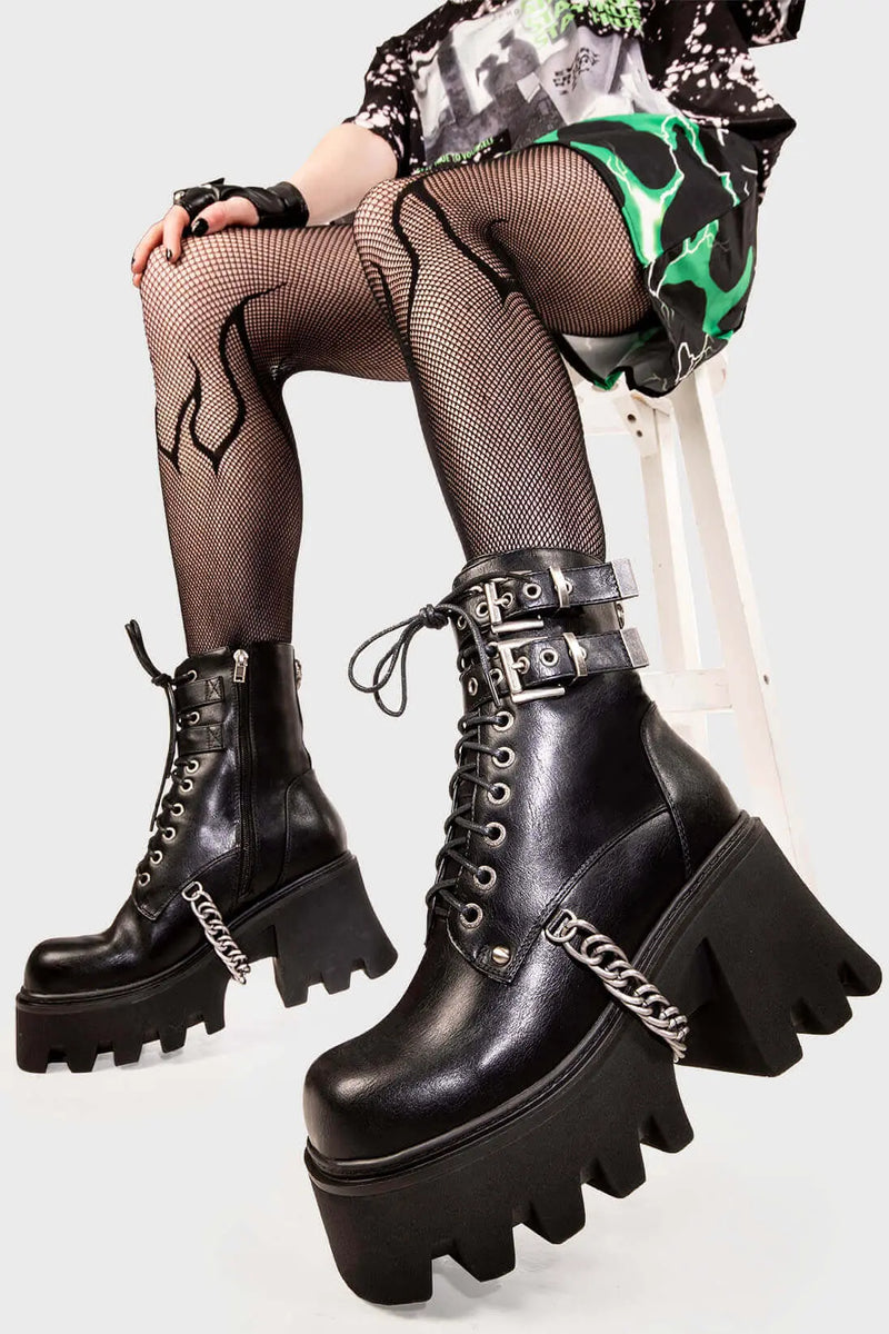 Break Free
  
  Hostages Chunky Platform Ankle Boots in black faux leather. These black vegan Platform Boots feature lace up detail with silver eyelets and two black adjustable straps with square shaped buckles, the perfect fit for your style. Made with eco-friendly materials and 100% cruelty-free.
  
  
  - Platform Height: 3.3 inch
  - Black zipper
  - Lace up detail with silver eyelets
  - Black straps square shaped buckles 
  - Chunky platform sole
  - Round Toe
  - 100% vegan
